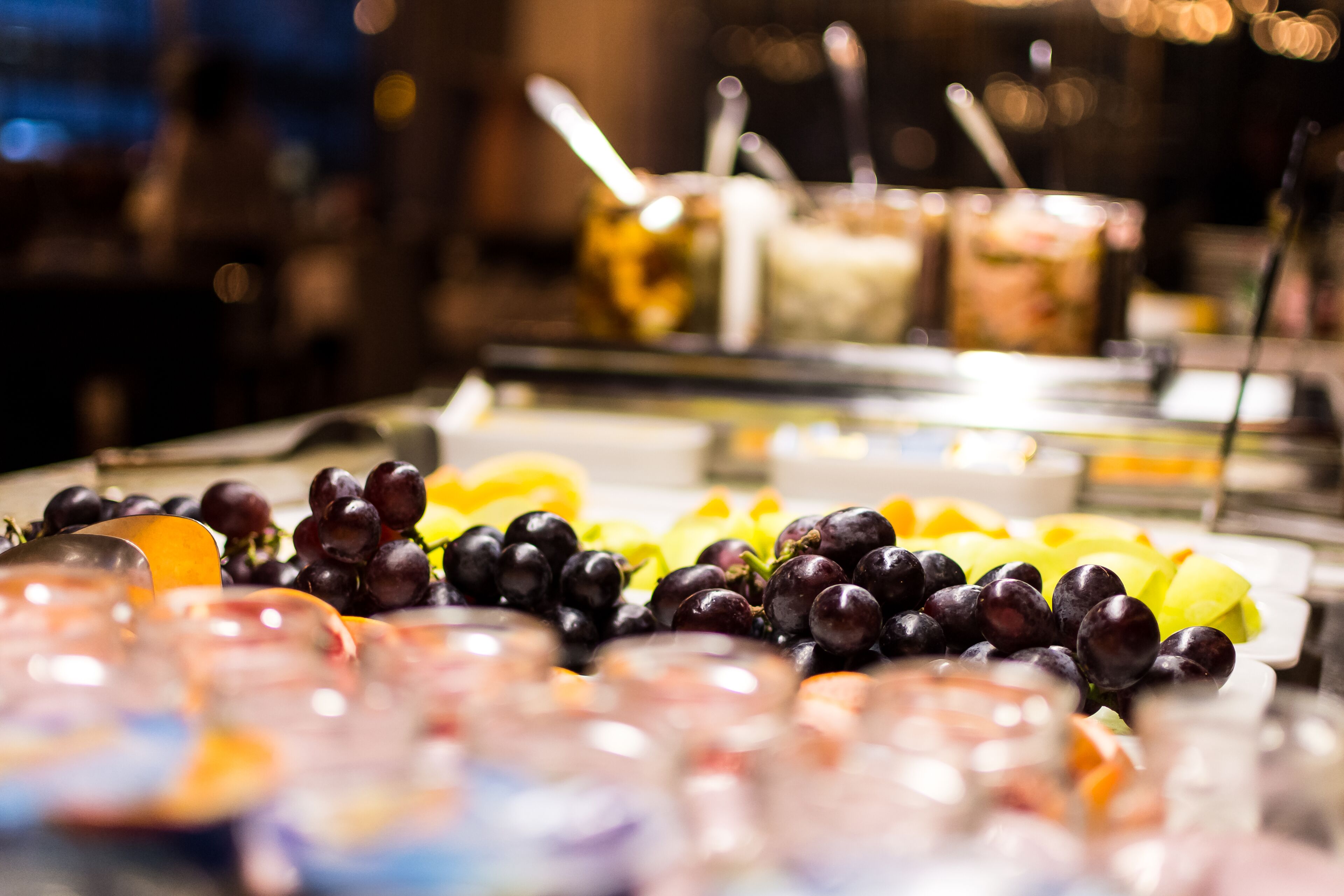 Ein reichhaltiges Buffet mit verschiedenen Speisen, darunter Trauben und Obstsalat.