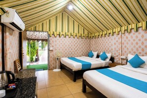 A hotel room with two beds, a fan, and a kitchenette. - Unity Holiday Resort Statue of Unity (Kevadia)
