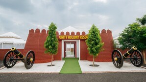 Ein Unity Holiday Resort mit Backsteinfassade, einem grünen Eingang und je einer Kanone auf jeder Seite.