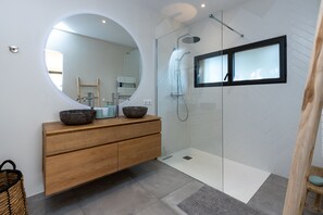 Een bad/douchecombinatie, een haardroger, handdoeken, zeep