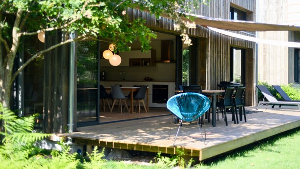 Una casa moderna con terrazza, zona pranzo e poltrone relax.
