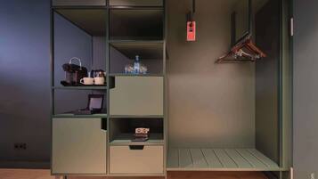 Un moderno mueble de almacenamiento escalonado con estantes, un perchero y una pequeña zona de escritorio.