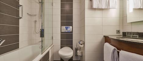 A modern bathroom with a glass-enclosed shower, a toilet, and a sink with a towel rack.