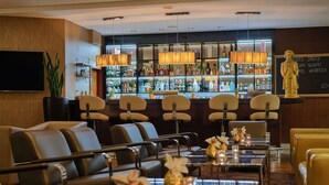 A bar area with multiple seating options, a well-stocked liquor display, and a statue on the wall. - Dorint Hotel Bonn (Bonn)