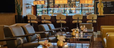 A bar area with multiple seating options, a well-stocked liquor display, and a statue on the wall.