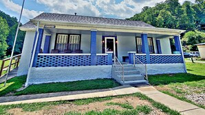 A two-story building with a porch, a staircase, and a sign that reads "Quick Stay". - Cozy & Convenient - 20 Minutes to Charleston WV (Elkview)