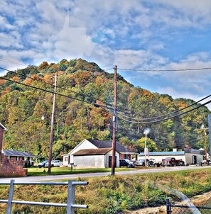A residential area with houses, a hill with trees, and power lines. - Cozy & Convenient - 20 Minutes to Charleston WV (Elkview)