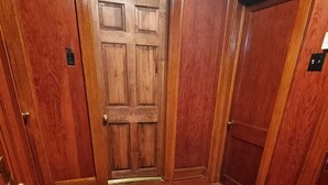 A hallway with wooden floors and doors, a doormat, and a metal vent. - Cozy & Convenient - 20 Minutes to Charleston WV (Elkview)