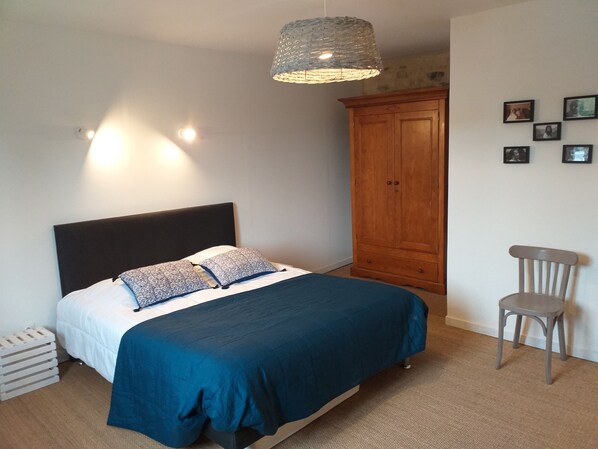 A bedroom with a bed, a wardrobe, a chair, and wall-mounted lights. - La ferme d'Omaha, in the heart of an orchard and 2km from Omaha beach (Colleville sur mer)