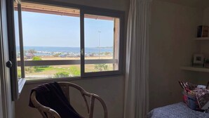 A room with a large window offering a view of the sea and distant land. - Discount (already subtracted) of -40% (Lecci)
