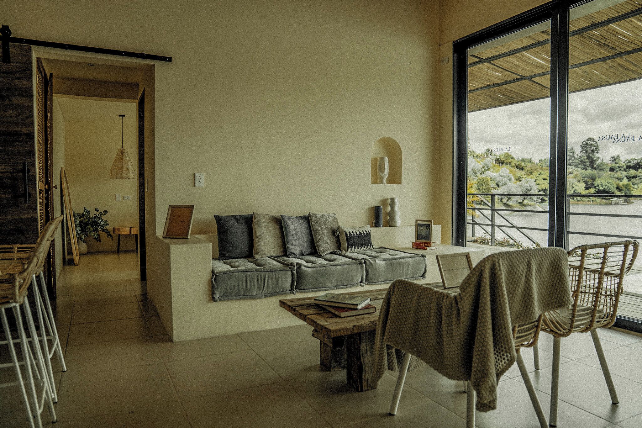 Een moderne woonkamer met een bank, een salontafel en uitzicht op een balkon.