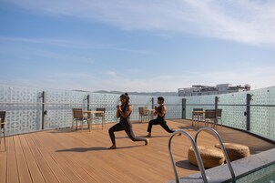 Terraza en la azotea con piscina, zona de ejercicios y asientos.