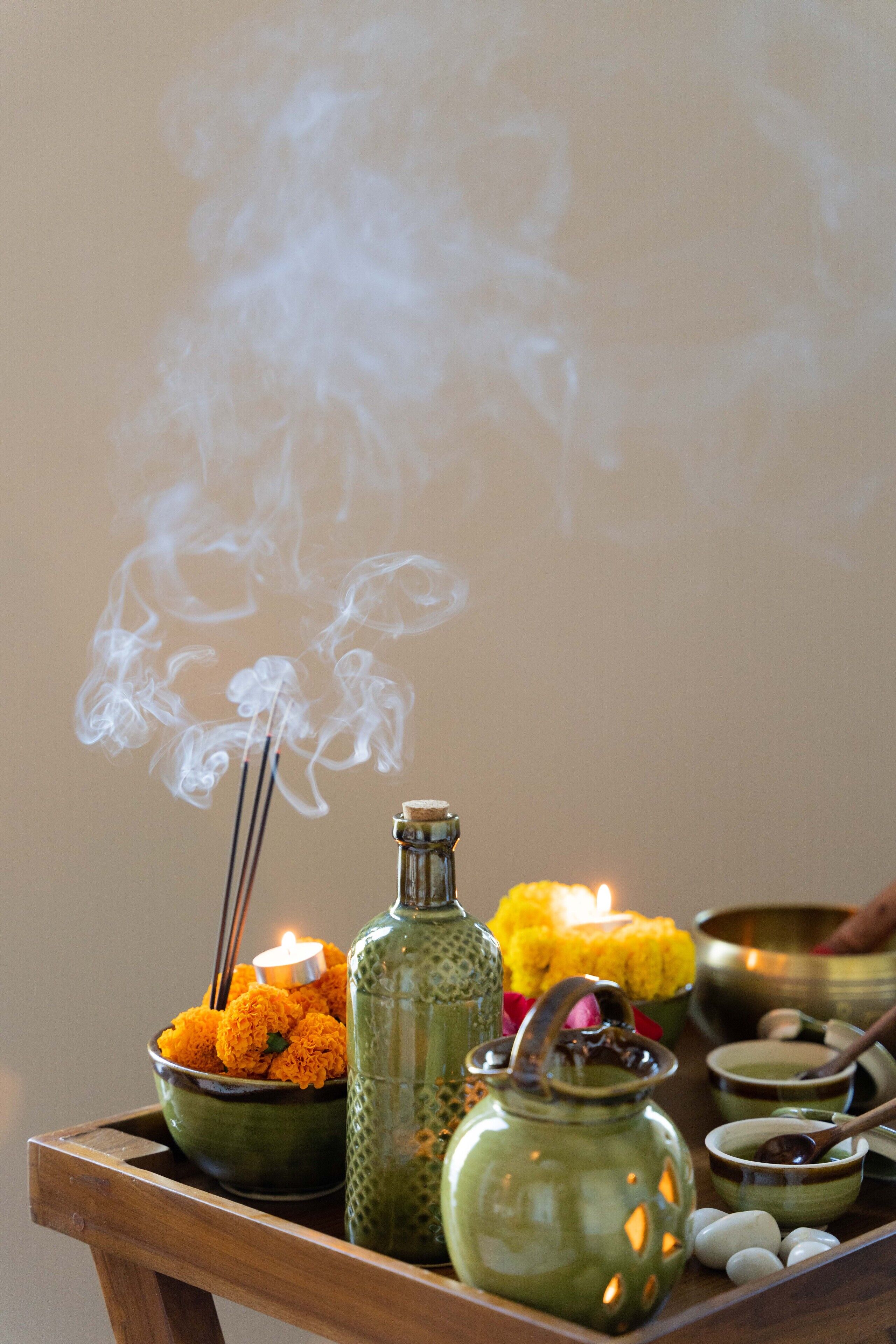 A tray with incense sticks, a candle, and various bowls and jars.
