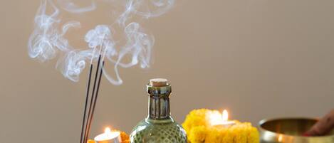 A tray with incense sticks, a candle, and various bowls and jars.