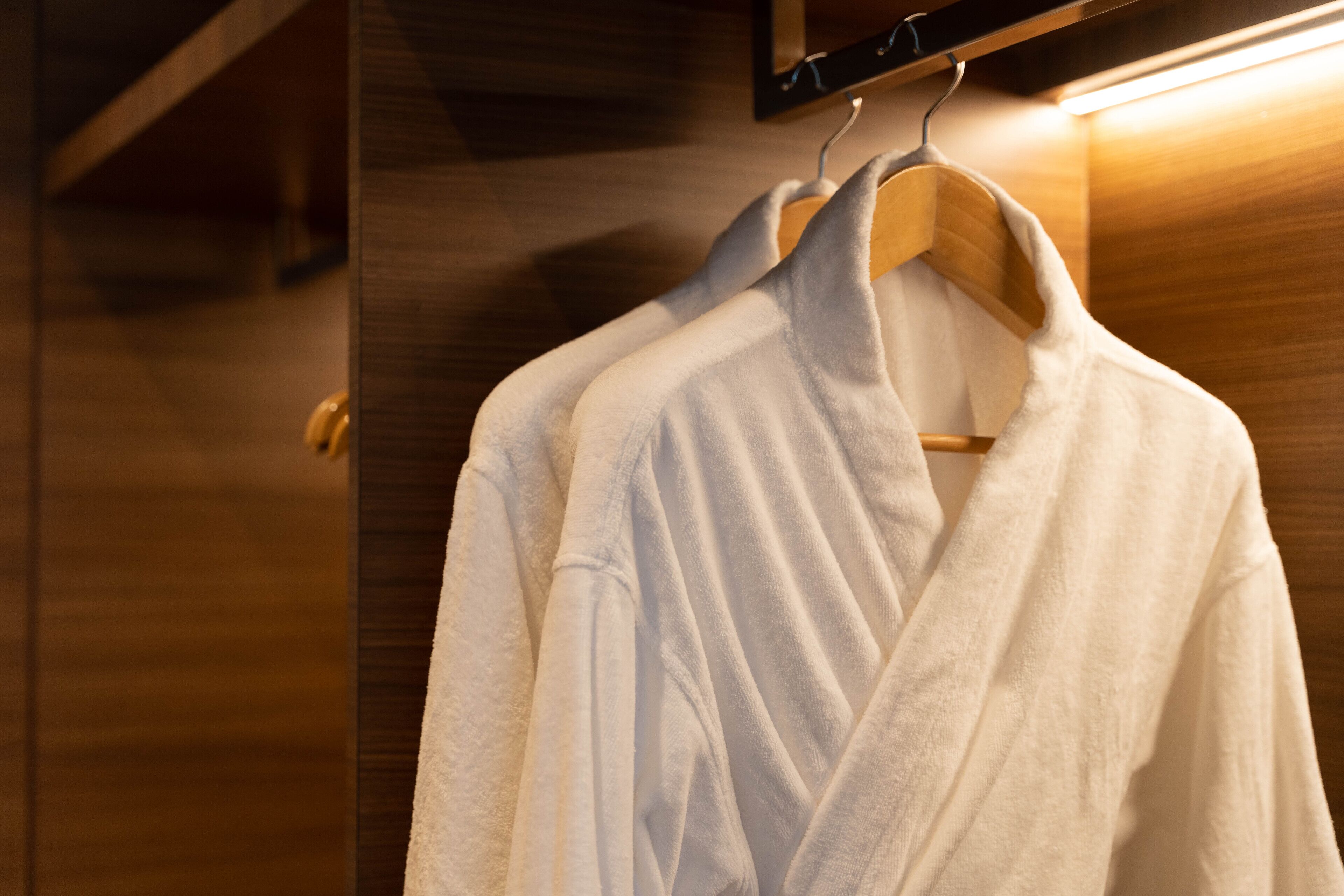 Une armoire en bois avec un manteau suspendu.