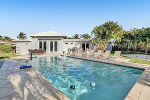 A swimming pool with a swan statue, lounge chairs, and a building with a patio. - Resort Villa 6 BR Hted Pool Beach Volleyball (Lighthouse Point)