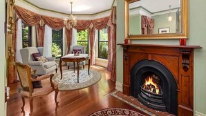 A room with a fireplace, a round table, and a sofa. - The Castle Lilli Pilli Beach (LILLI PILLI)