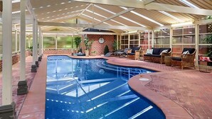 An indoor swimming pool with lounge chairs and a brick wall. - The Castle Lilli Pilli Beach (LILLI PILLI)