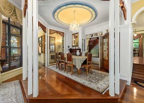 A dining area with a chandelier, wooden chairs, a table, and a staircase. - The Castle Lilli Pilli Beach (LILLI PILLI)