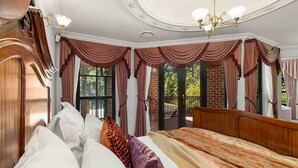 A bedroom with a large bed, a wooden wardrobe, and a chandelier. - The Castle Lilli Pilli Beach (LILLI PILLI)