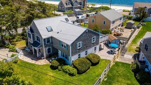 A residential area with houses, a swimming pool, and a beach in the background. - 🌊 BEACHFRONT FAMILY HOME - 2026 Vrbo Rental Of The Year Award! (Yarmouth)