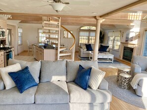 Cozy living area with a fireplace, comfortable seating, and a dining area with a kitchen.