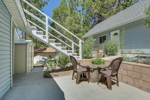A patio with a table and chairs, a white staircase, and a house with a covered porch. - Ski, Hike & Fish: Big Bear Lake Home w/ Fire Pit (Big Bear Lake)