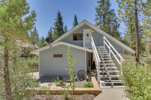 A small, light blue cabin with a white staircase leading to a door, surrounded by trees. - Ski, Hike & Fish: Big Bear Lake Home w/ Fire Pit (Big Bear Lake)