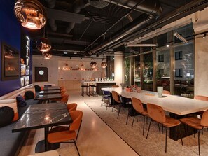 A modern interior with a bar area, seating, and a kitchen. - Tribe Paris Saint Ouen (Saint-Ouen)