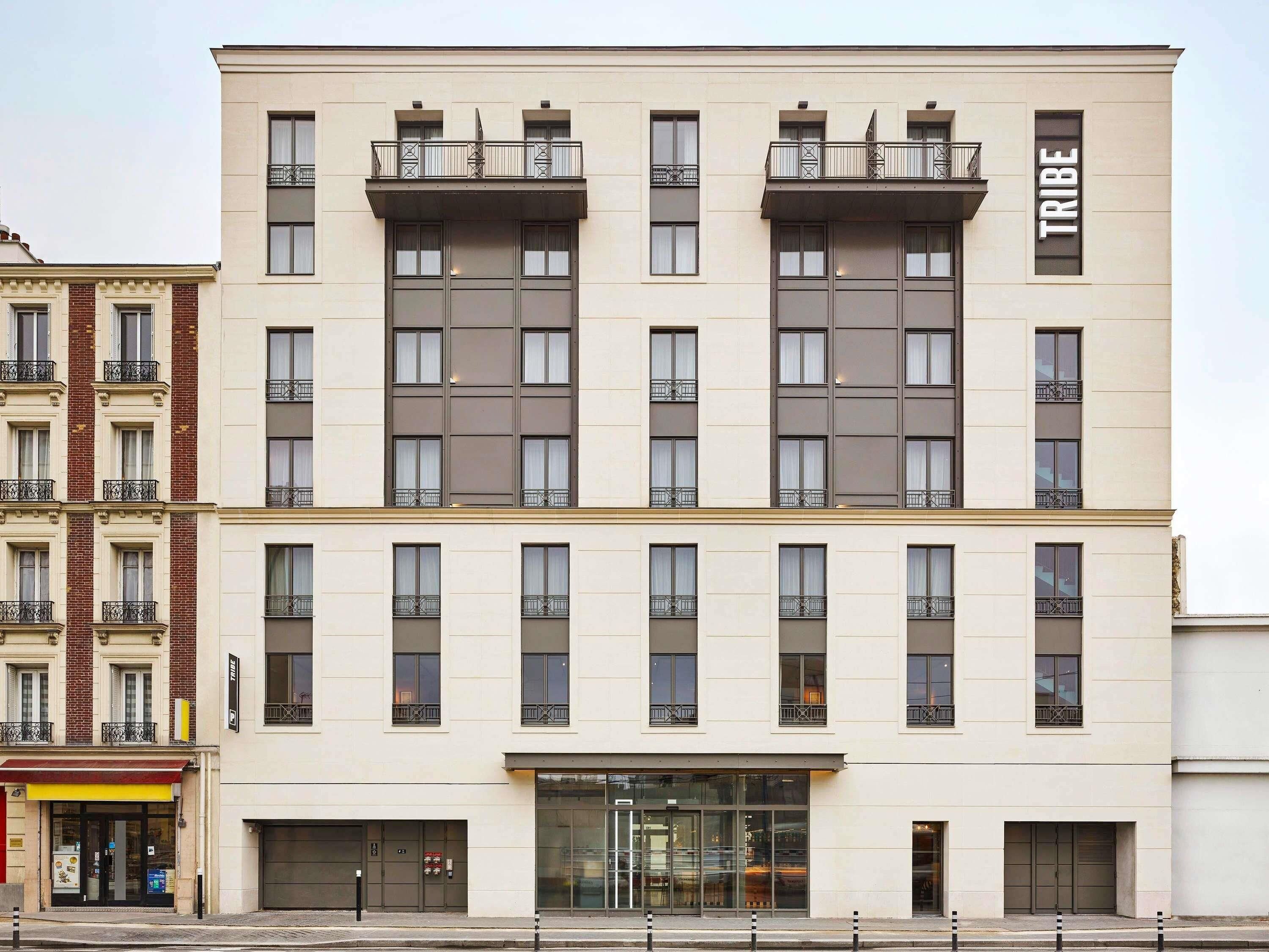 Een meerlaags hotel met een moderne gevel, balkons en een entree op begane grond.