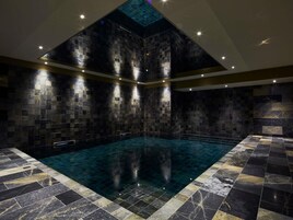 Una piscina techada, sillones reclinables de piscina