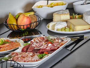 A variety of food items including meats, cheeses, and fruits arranged on a table. - La Licorne Hotel & Spa Troyes - MGallery Collection (Troyes)