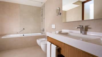 Un baño moderno con cabina de ducha de vidrio, inodoro blanco y tocador con espejo.