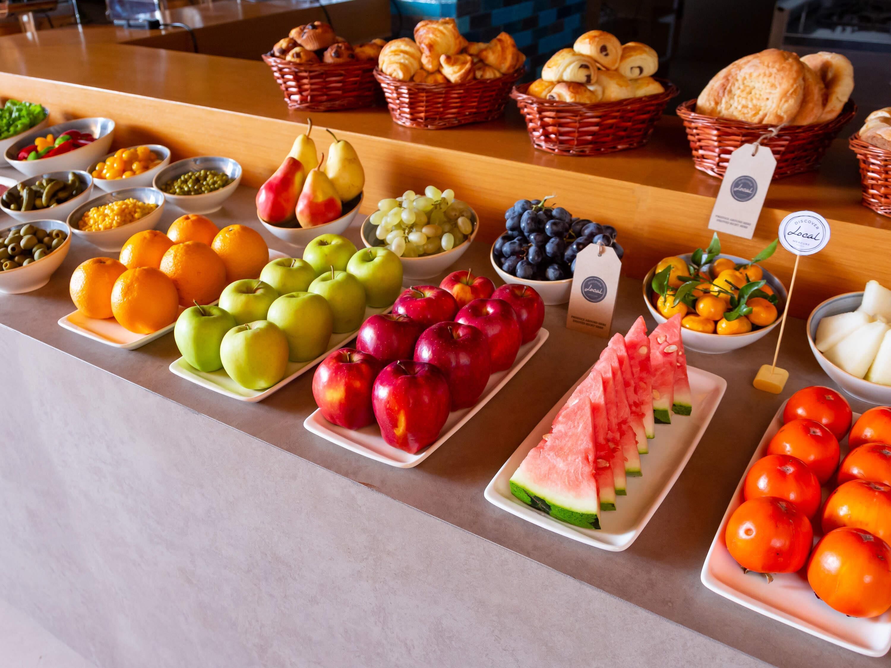 Un buffet con diverse varietà di frutta e dolci.