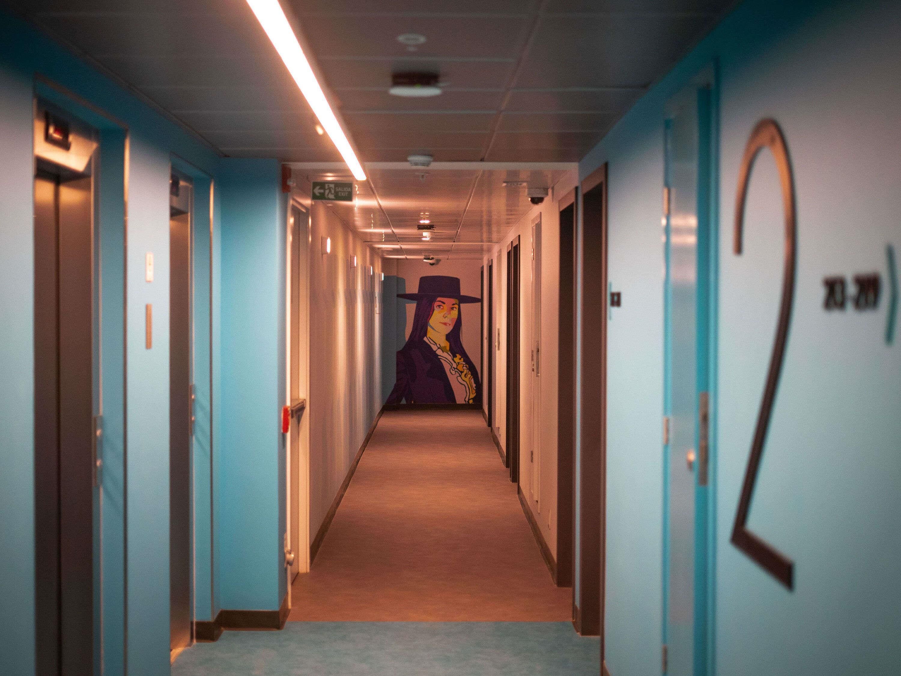 A hallway with doors numbered 2 and 3, a corridor with a carpeted floor, and a wall with a mural.