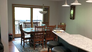 Una cocina moderna con sillas de madera, una barra y lámparas colgantes.
