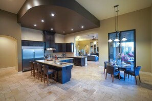A spacious kitchen with a central island, dark cabinetry, and a dining area with a glass partition. - DesertOasis/4Beds/4 Baths/Pool/Jacuzzi/Golf/Wifi/Privacy (Scottsdale)