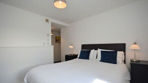 Une chambre à coucher avec un grand lit, deux lampes de chevet et un luminaire au plafond.