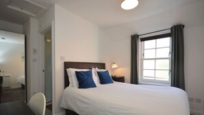 Een hotelkamer met een groot bed, een bureau en een stoel.