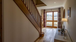 Una escalera de madera que lleva a una habitación con vistas al exterior.