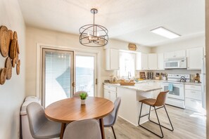 Enjoy cooking in this well-equipped kitchen with a central island, dining table, and microwave, oven, and utensils.