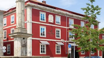 Un edificio rojo con una estatua sobre un pedestal.