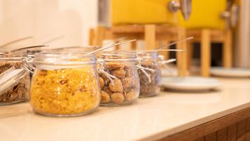 A row of glass jars with metal clasps containing various food items on a countertop.