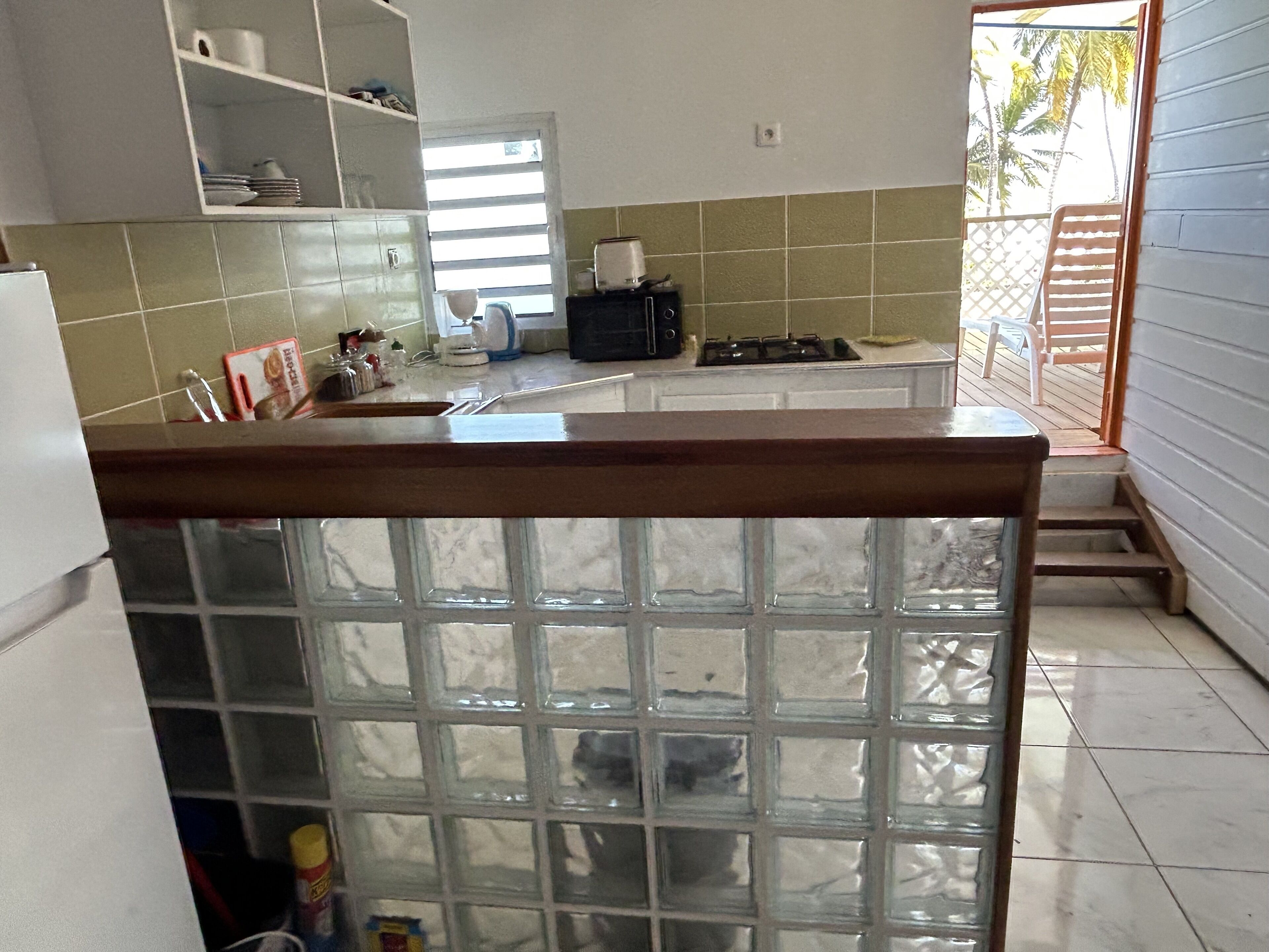 A kitchen with a window, a refrigerator, and a sink.