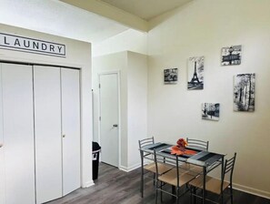 Cozy retreat with a dining area, wardrobe, and hallway leading to another room.