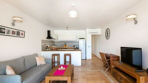 A modern living room with a grey sofa, wooden coffee table, and a TV stand. - SALT 6: swimming pool, direct access to Orient Bay beach (saint Martin)
