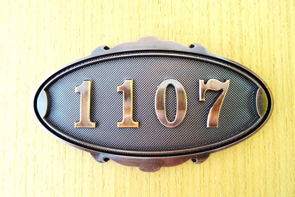 A house number plaque with the digits 1107 on a textured background.