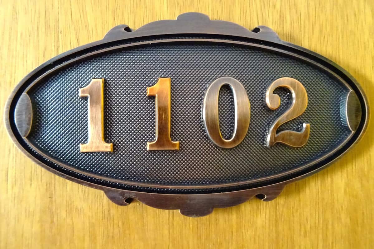 A house number plaque with the numbers 1102.