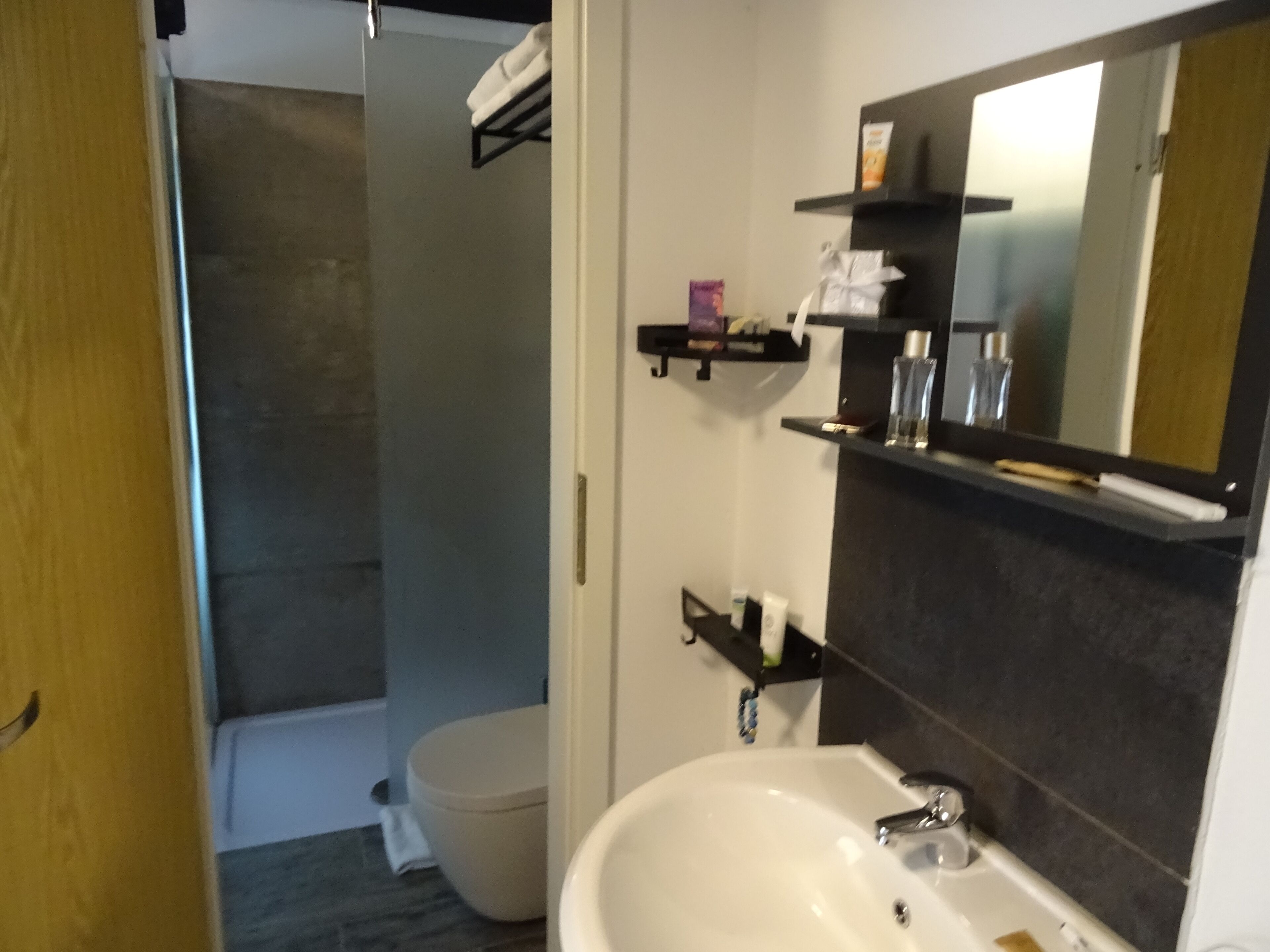 A bathroom with a white sink, a mirror, and a shower area.