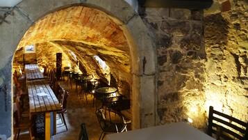 Enjoy communal dining and socializing in this traditional space with an arched ceiling and rustic stone wall.